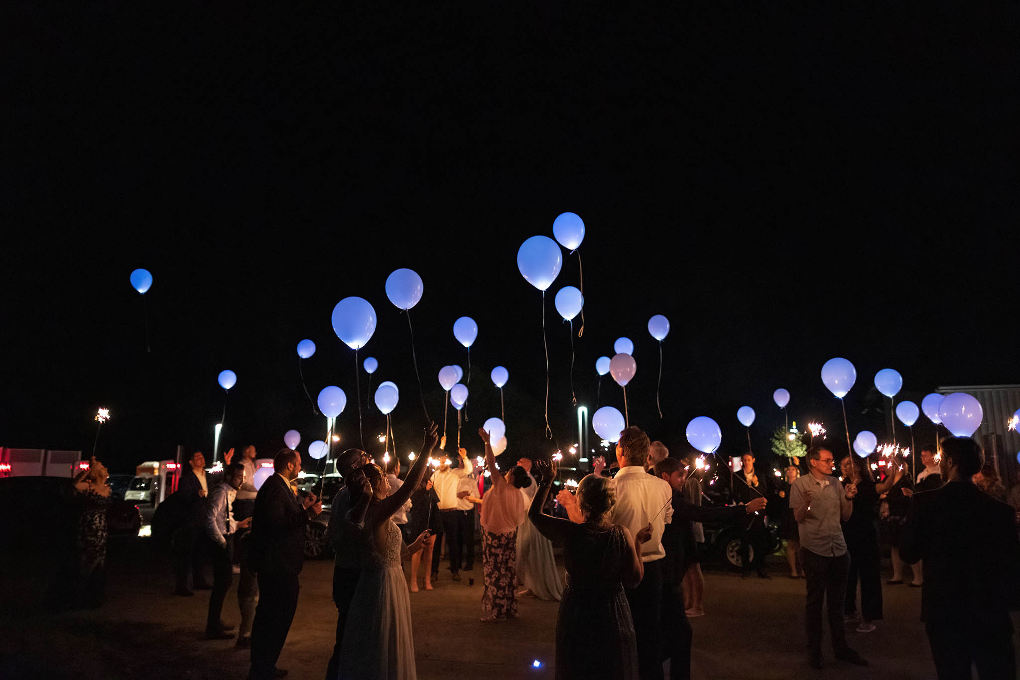 Hochzeitsgesellschaft lässt leuchtende Luftballons in der Nacht steigen